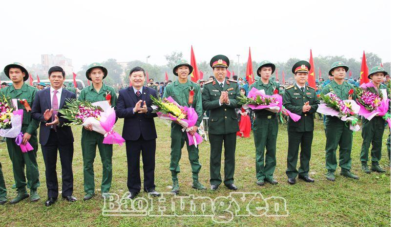 Description: Đồng chí Nguyễn Văn Phóng, Phó Bí thư Tỉnh ủy, Chủ tịch UBND tỉnh, Chủ tịch Hội đồng nghĩa vụ quân sự tỉnh và các đại biểu tặng hoa, động viên thanh niên huyện Khoái Châu lên đường nhập ngũ